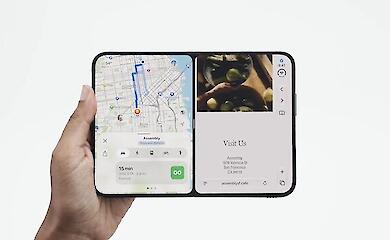 A foldable smartphone, unfolded, with two apps open on the large inner screen.