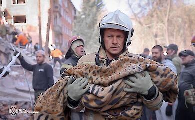 Pryluky, 7 October 2026. A rescuer is carrying a child who has been pulled from the rubble of a residential building
